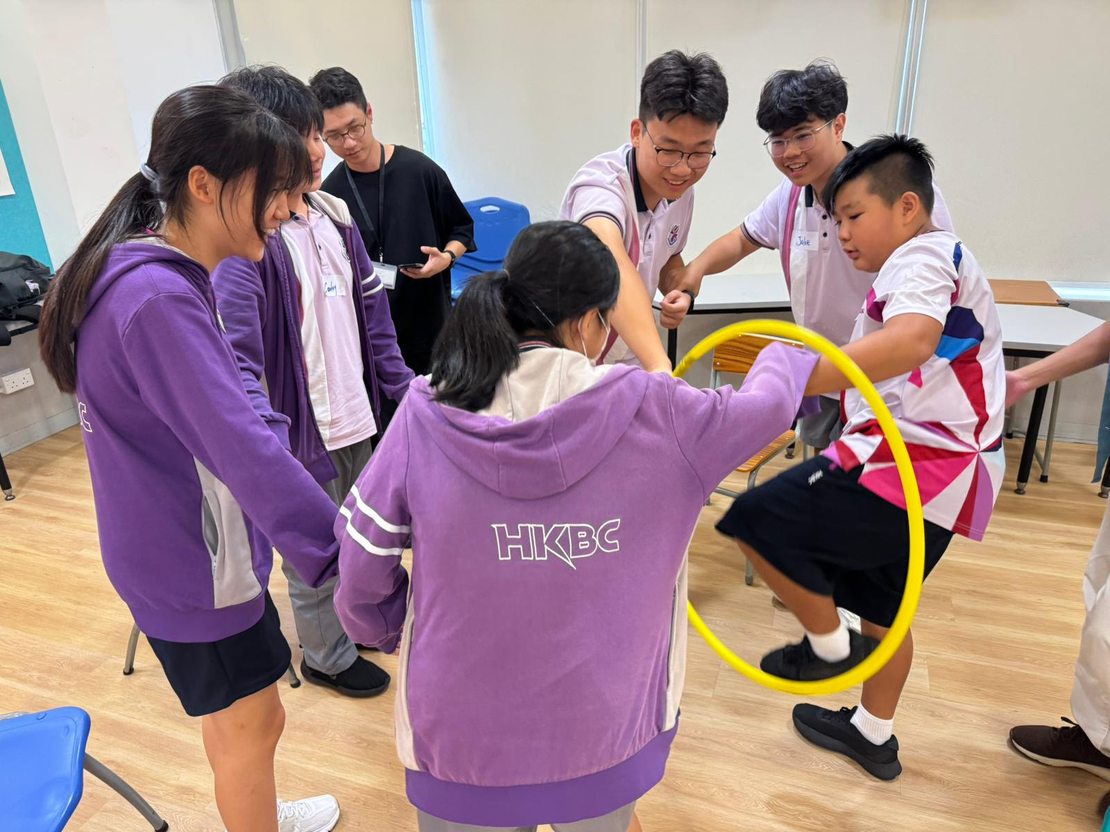 香港紫荊書院學生在領袖培訓活動中合作傳遞黃色圓環。